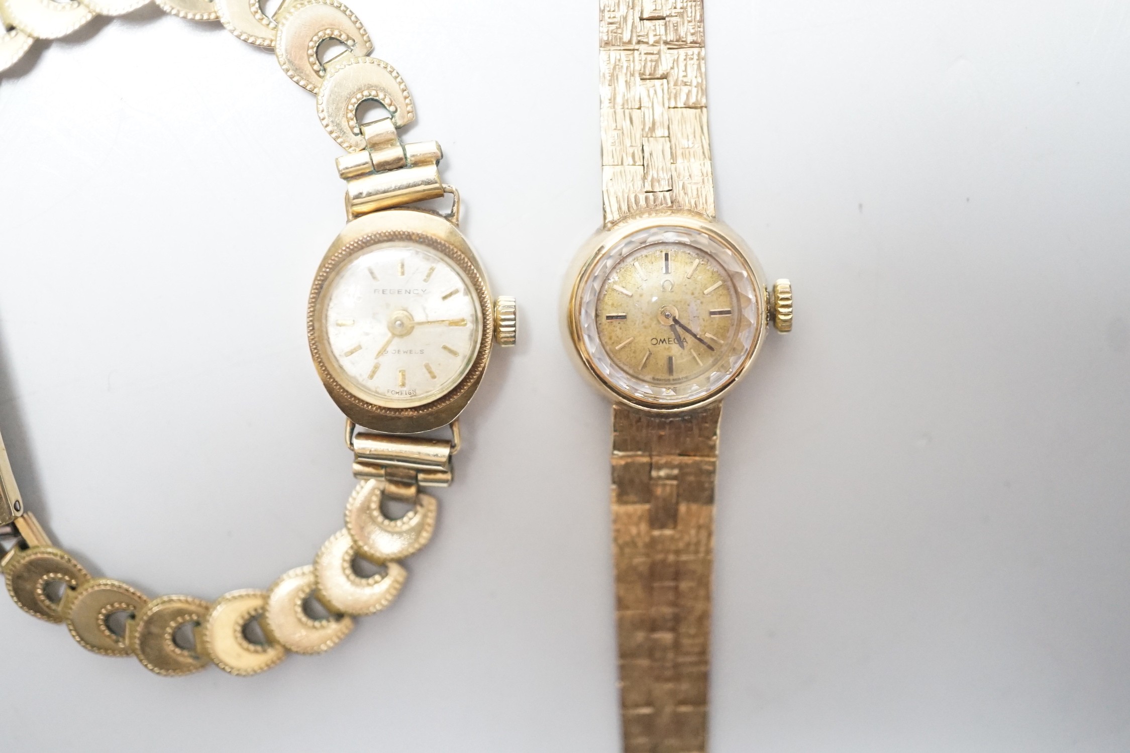 A lady's 9ct gold Omega manual wind wrist watch, on associated 9ct gold bracelet, overall 15.8cm, gross weight 17.8 grams and one other lady's 9ct gold watch on a gold plated bracelet.